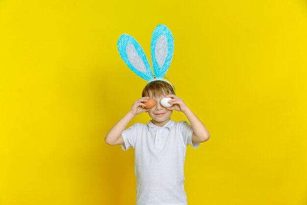 Cheerful happy child boy with easter eggs and bunny ears