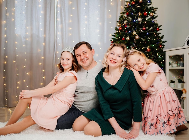 A cheerful happy family sitting near the christmas tree