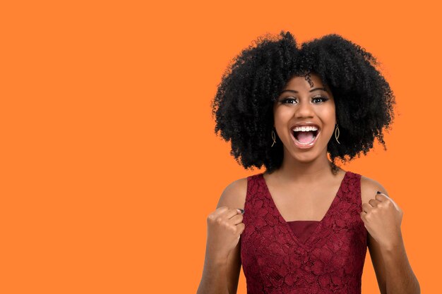 A cheerful and happy young girl with afro hair proves to be the winner raises her clenched fists in