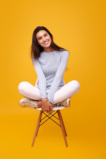 Cheerful Hispanic female sitting on chair