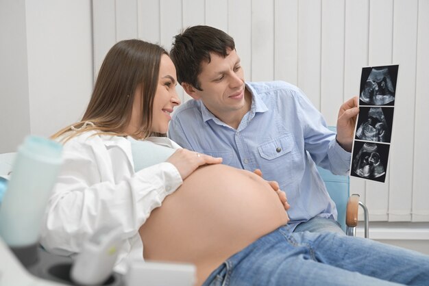 Cheerful husband and wife looking at x ray of future baby.