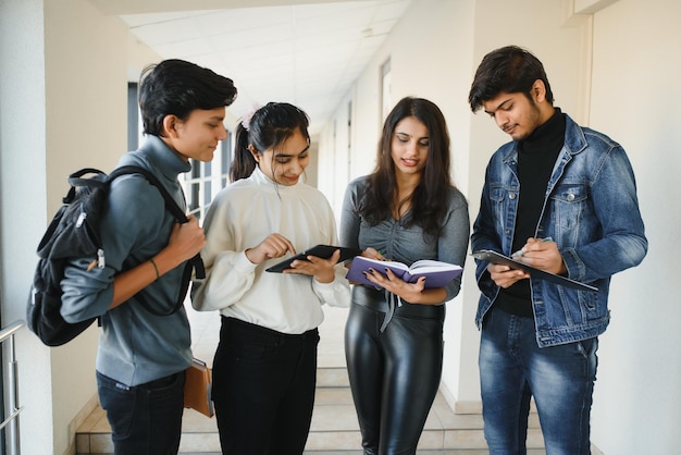 Giovane gruppo asiatico indiano allegro di studenti universitari.