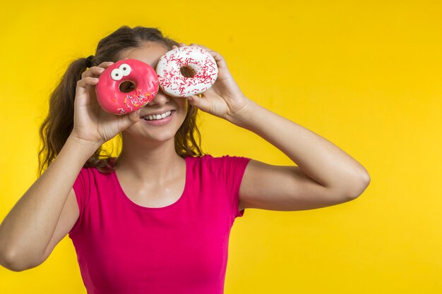 Cheerful Indian girl holding sweet donuts