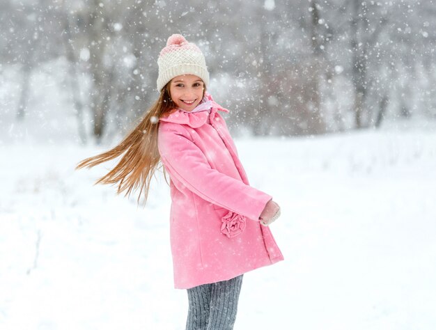 Cheerful kid having fun in winter forest