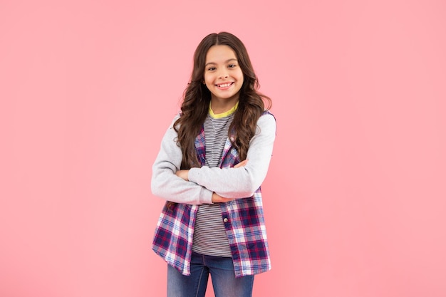 Cheerful kid with curly hair on pink background childhood