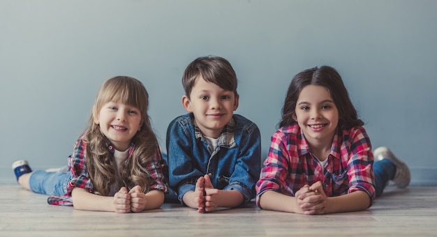 Cheerful kids in casual clothes are looking at camera.