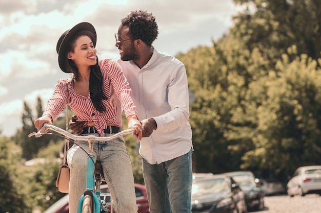 彼女のボーイフレンドに微笑んで自転車に乗って陽気な女性。ウェブサイトのバナー