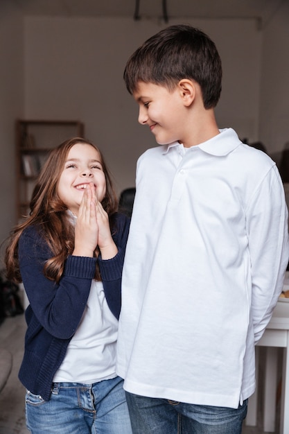 Cheerful little boy and girl talking and laughing together