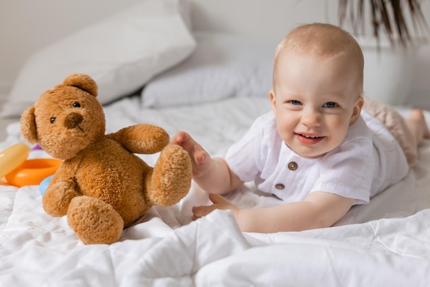 Cheerful little boy playing with toys on blanket, teddy bear, health, banner, card