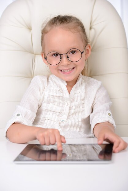 Cheerful little girl in glasses and formalwear.