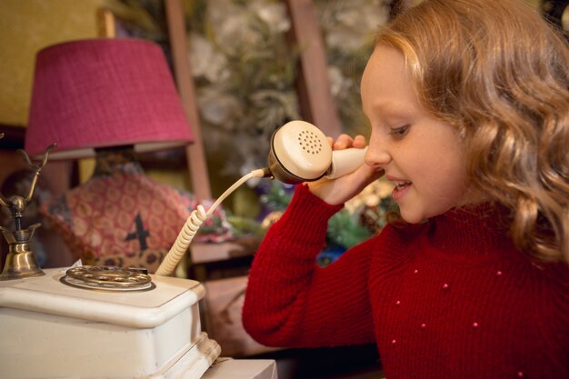 Bambina allegra che cerca decorazioni per la casa e regali per le vacanze nel negozio di casalinghi