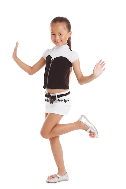 Cheerful little girl posing in fashionable clothes