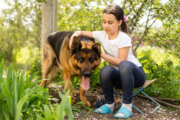 Cheerful little girl with a dog German shepherd.