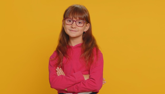 cheerful lovely young preteen child girl kid smiling looking at camera on studio yellow background