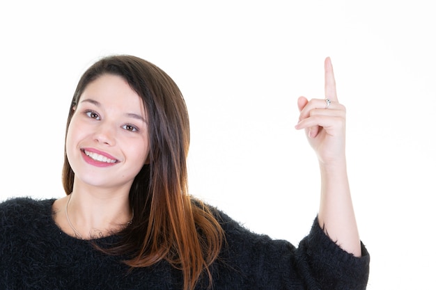 Cheerful lovely young woman standing and pointing away