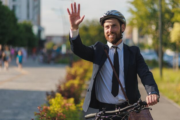 Фото Веселый мужчина-бизнесмен показывает привет коллеге на улице