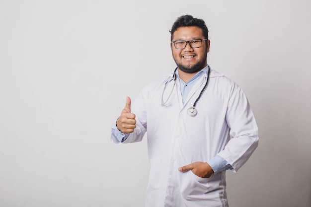 Веселый врач-мужчина с жестом вверх на белом фоне с копировальным пространством