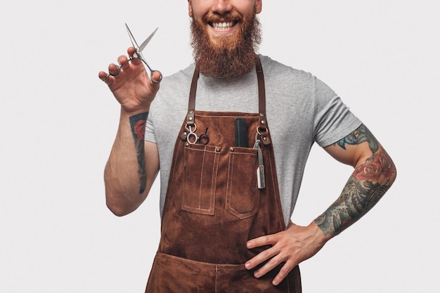 Photo cheerful male hairdresser showing scissors