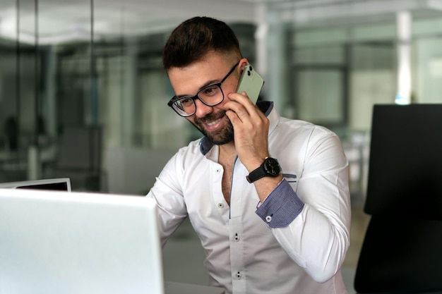 Cheerful male IT professional in bluetooth earbuds doing distance job keeping freelance lifestyle