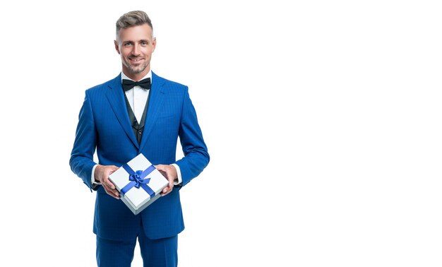 Cheerful man in blue suit with gift box isolated on white valentines day