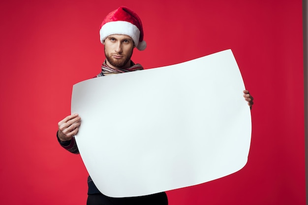 クリスマスの白いモックアップポスタースタジオでポーズをとっている陽気な男 高品質の写真