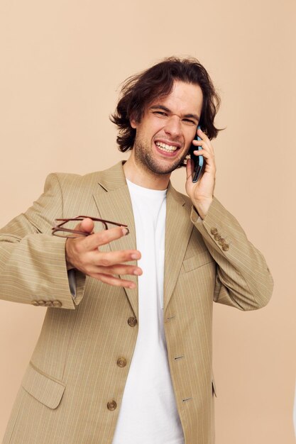 Foto comunicazione uomo allegra per telefono vestito beige stile elegante stile di vita inalterato