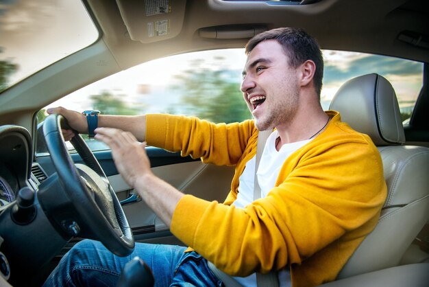 Foto uomo allegro che guida un'auto