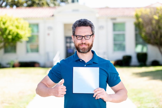 Cheerful man in eyeglasses showing paper thumb up vision acuity eyesight vision correction