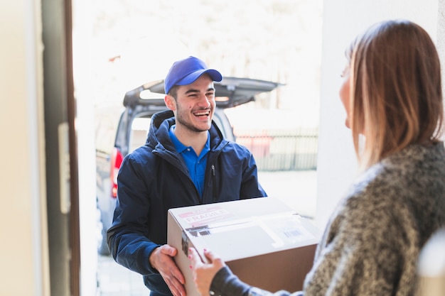 Photo cheerful man giving parcel to client