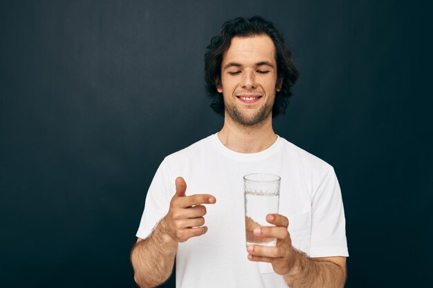 Cheerful man glass of water in his hands emotions posing beige background