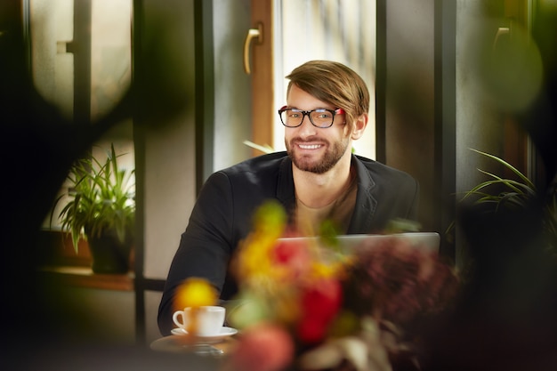 Photo cheerful man in glasses at laptop