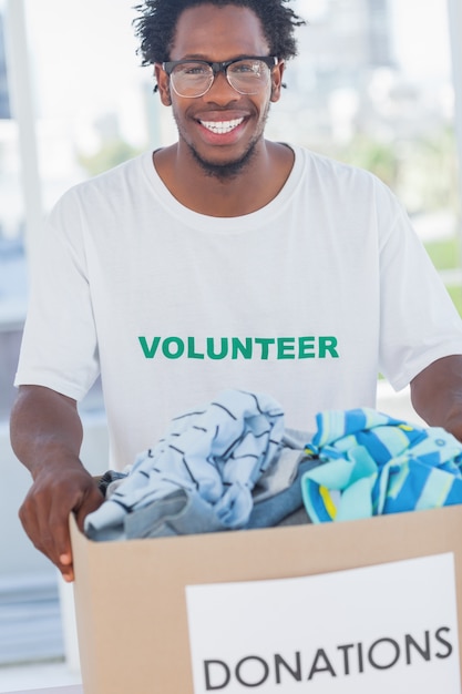 Cheerful man holding donation box