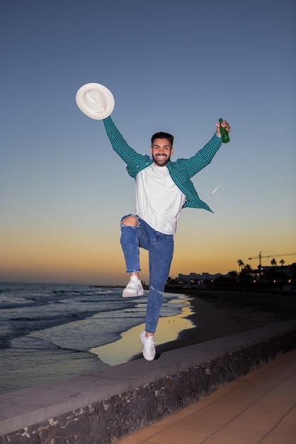 Cheerful man jumping with beer