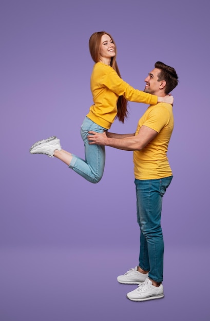 Cheerful man lifting jumping woman