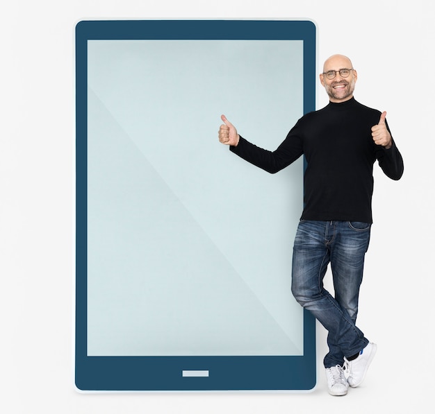 Cheerful man standing beside a tablet