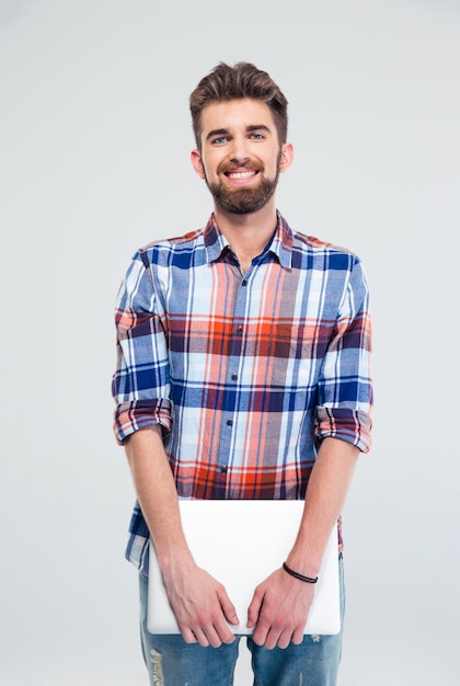 Cheerful man standing and holding laptop