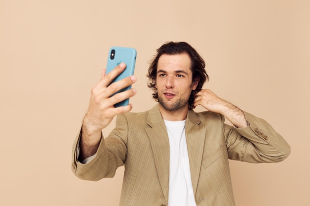 Cheerful man in a suit posing emotions looking at the phone isolated background