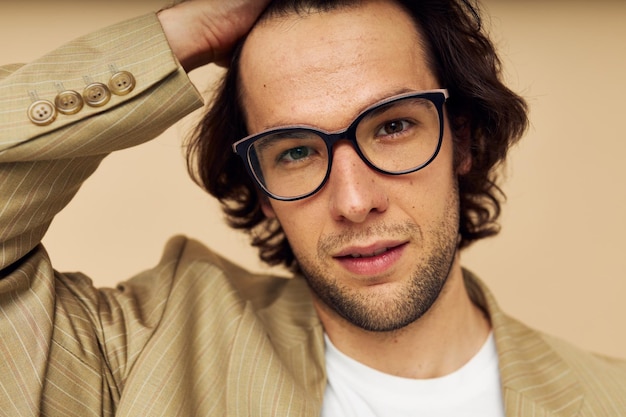 Photo cheerful man in a suit posing emotions wear glasses beige background