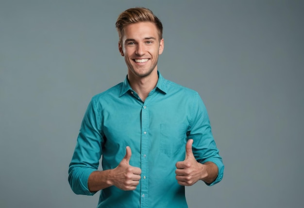 Веселый мужчина в синей рубашке, поднимающий два пальца, излучающий уверенность и счастье в сером
