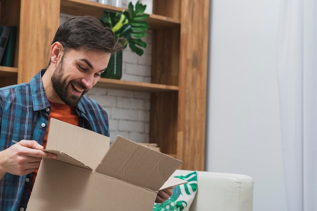 Photo cheerful man with opened parcel