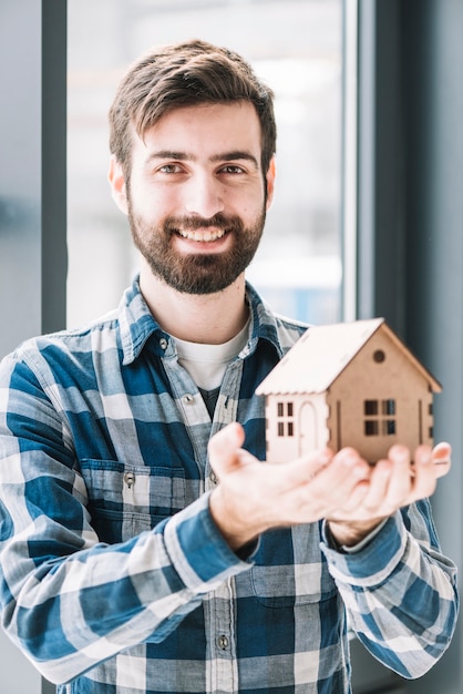 Foto uomo allegro con la casa del giocattolo