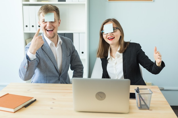 Cheerful man and woman playing games in office while working.