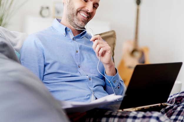 Cheerful man working home on the lapto