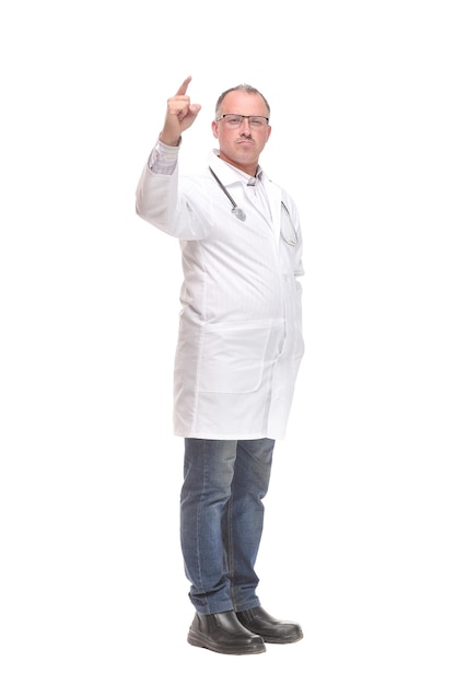 Cheerful mature doctor looking at camera and pointing away while standing against white background