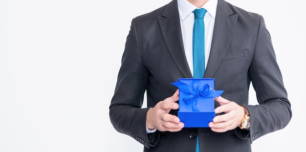 cheerful mature man in eyeglasses and suit hold present box isolated on white background