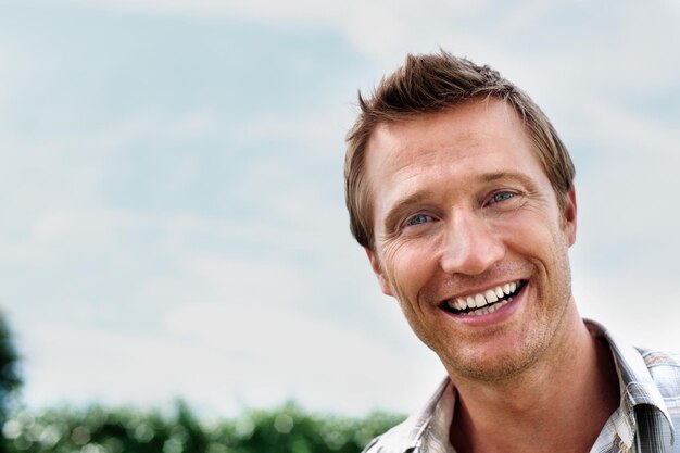 Cheerful mature man smiling against sky copyspace Closeup portrait of a cheerful mature man smiling against sky copyspace