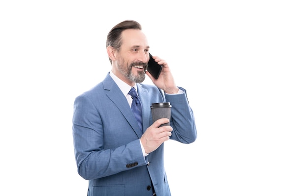 Cheerful mature man in suit talking on phone and drink coffee isolated on white conversation