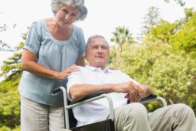 Cheerful mature man in wheelchair with his partner