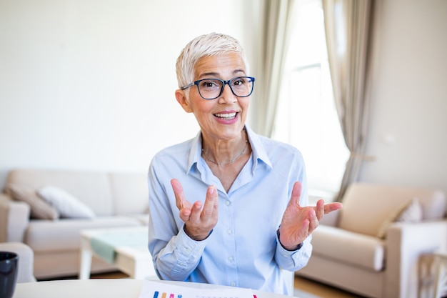 Cheerful mature woman having a video call from home