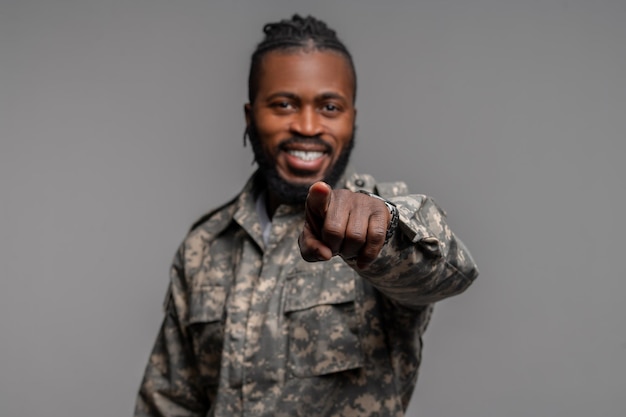 Cheerful military man poking at the camera